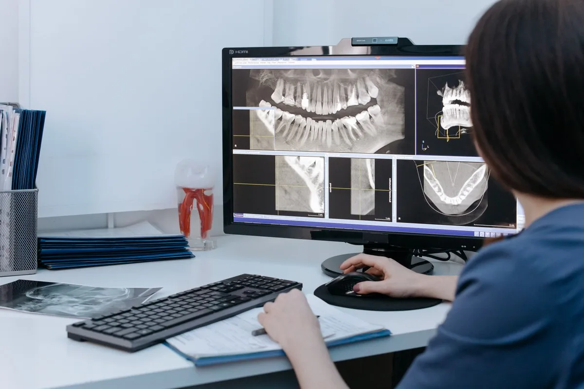Dental professional reviewing dental X-rays on a monitor